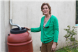 Lisa Sheridan next to her rain barrel.